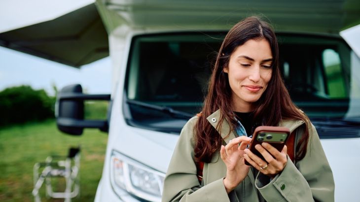 Žena u obytného auta sjednává pojištění Vansafe online